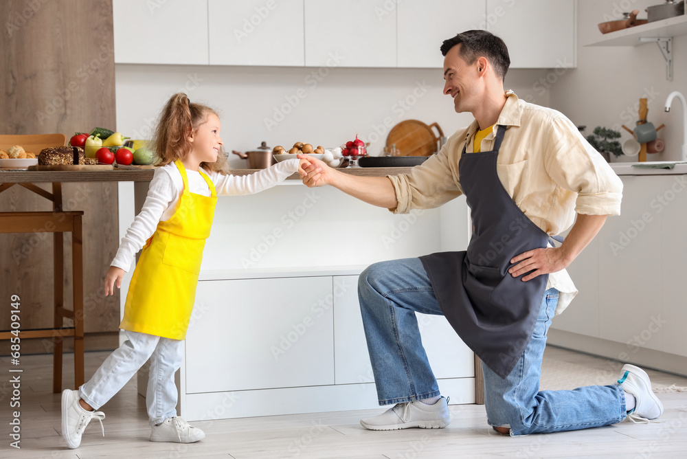 Cute little girl with her dad in kitchen