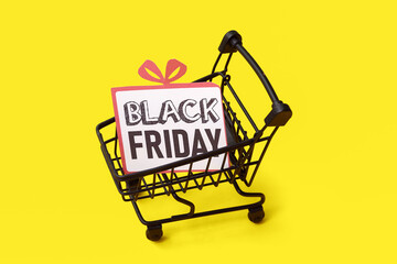 Poster - Greeting card with text BLACK FRIDAY in shopping cart on yellow background