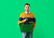 canvas print picture - Young man with shopping basket on green background
