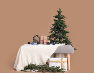 Soft bench with Christmas presents and fir tree on brown background