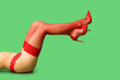 canvas print picture - Legs of beautiful young sexy woman lying on green background, closeup