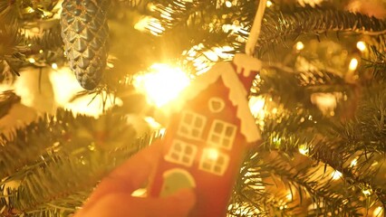 Sticker - Christmas vintage toys.red gingerbread house in hand in the rays of the sun on a festive Christmas tree.Christmas tree decor.Christmas tradition. 4k footage