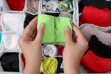 Wall Mural - Woman rolling socks above organizers with underwear in drawer, top view