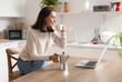© Pixel-Shot - Pretty young woman with geyser coffee maker, cup of espresso and laptop in modern kitchen