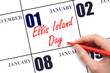 January 1. Hand writing text Ellis Island Day on calendar date. Save the date.