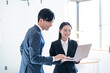 © ponta1414 - オフィスで話す笑顔の若手ビジネスマン2人