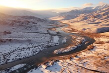 Winding River At Dusk: Aerial Shot Of A Serpentine River Carving Through A Snowy Landscape