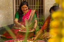 Mother-in-law And Daughter-in-law Decorating House With Lamps And Flowers On The Occasion Of Diwali