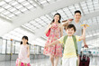 © Blue Jean Images - Happy family with luggage at the airport