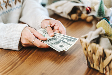 Wall Mural - Girl counting US Dollar bills, and planning expenses for Christmas. Woman doing budget, estimating money balance for shopping spree. Female accountant paying taxes. Girl counting Christmas gifts.