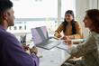 © DragonImages - Businessman presenting ideas to smiling coworkers in meeting
