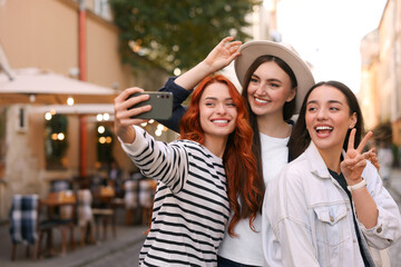 Wall Mural - Happy friends taking selfie on city street