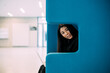 © Westend61 - Beautiful businesswoman sitting with laptop on blue chair at workplace