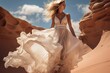 Fashion model elegantly poses in desert sands, wearing fluttering long dress on sunny day.