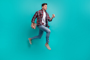 Poster - Full length photo of funky cheerful guy wear checkered shirt walking holding modern device jumping high isolated teal color background