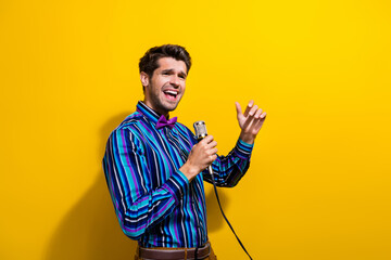 Sticker - Photo of emotional man dressed striped shirt bow tie sing lyric song in microphone look empty space isolated on yellow color background