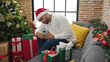 © Krakenimages.com - African american man make photo to christmas gift at home