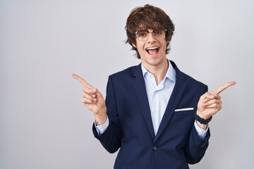 Canvas Print - Hispanic business young man wearing glasses smiling confident pointing with fingers to different directions. copy space for advertisement