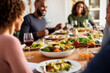 © SnapVault - A group of friends enjoy each other's company with a meal together at home, sharing moments of joy and fun.