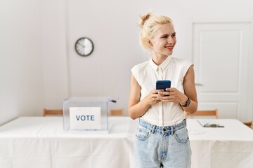 Poster - Young blonde woman using smartphone smiling at electoral college