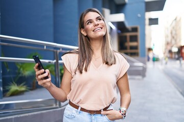 Poster - Young beautiful hispanic woman smiling confident using smartphone at street