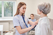 © Yakobchuk Olena - Experienced practitioner standing behind the patient and carefully listening to her lungs