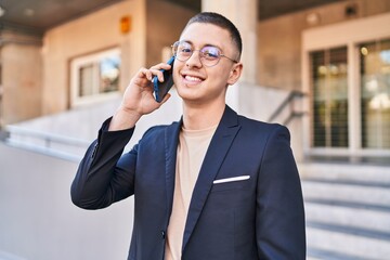 Sticker - Young hispanic man executive smiling confident talking on smartphone at street