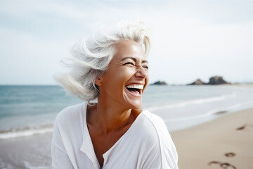 Wall Mural - a happy woman with white hair on a beach, leaving footprints in the sand, with the ocean in the background, ai generative