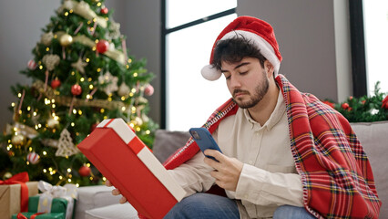 Poster - Young hispanic man celebrating christmas make photo to gift at home