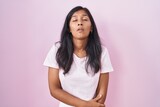 Fototapeta  - Young hispanic woman standing over pink background looking sleepy and tired, exhausted for fatigue and hangover, lazy eyes in the morning.