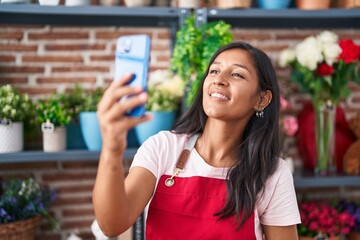 Sticker - Young beautiful hispanic woman florist make selfie by smartphone at flower shop