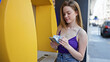 © Krakenimages.com - Young blonde woman holding hungary forint banknotes of cash machine at street