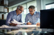 © Igor - Mature business executive colleagues doing paperwork.