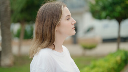 Poster - Young caucasian woman looking to the side with serious expression at park