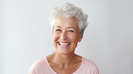 Portrait of Beautiful elder woman's smile with healthy white, straight teeth close-up on light background with space for text