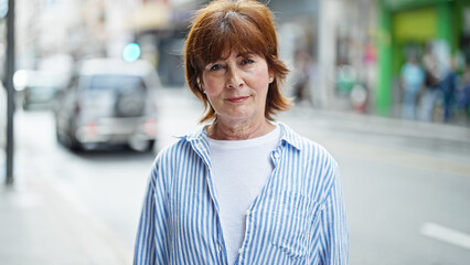 Sticker - Middle age woman standing with serious expression at street