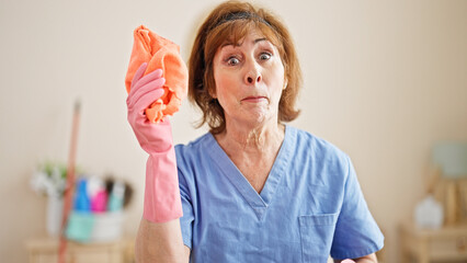 Wall Mural - Middle age woman professional cleaner angry screaming at bedroom