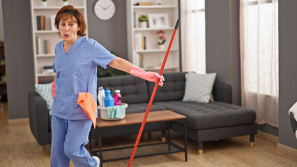 Poster - Middle age woman professional cleaner cleaning and dancing home