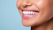 © masyastadnikova - Beautiful woman's smile with healthy white, straight teeth close-up on light-blue background with space for text