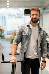 Wall Mural - Male entrepreneur leaving office while walking with bicycle at his side