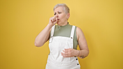 Sticker - Middle age grey-haired woman coughing over isolated yellow background