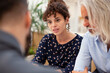 © PhotoAlto - Adult woman discussing with partner and lawyer during meeting
