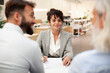 © PhotoAlto - Female bank worker having a meeting with two clients