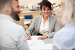 © PhotoAlto - Bank worker signing contract while talking with clients
