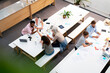 © PhotoAlto - Wide view of place of work full of people having casual meetings