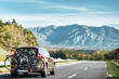 © AlexGo - Transporting Bicycles by Car for a Vacation. A Vehicle with a Bike Carrier and a Rear Rack on the Highway.