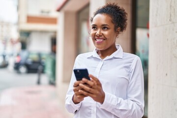 Wall Mural - African american woman smiling confident using smartphone at street