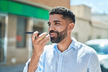 Sticker - Young arab man smiling confident talking on the smartphone at street