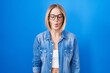 Young caucasian woman standing over blue background making fish face with lips, crazy and comical gesture. funny expression.