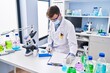 © Krakenimages.com - Young man scientist wearing medical mask weighing pills at laboratory